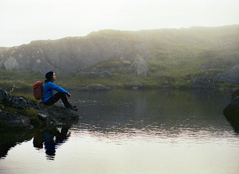 Woman sitting at a lake in Northern Norway